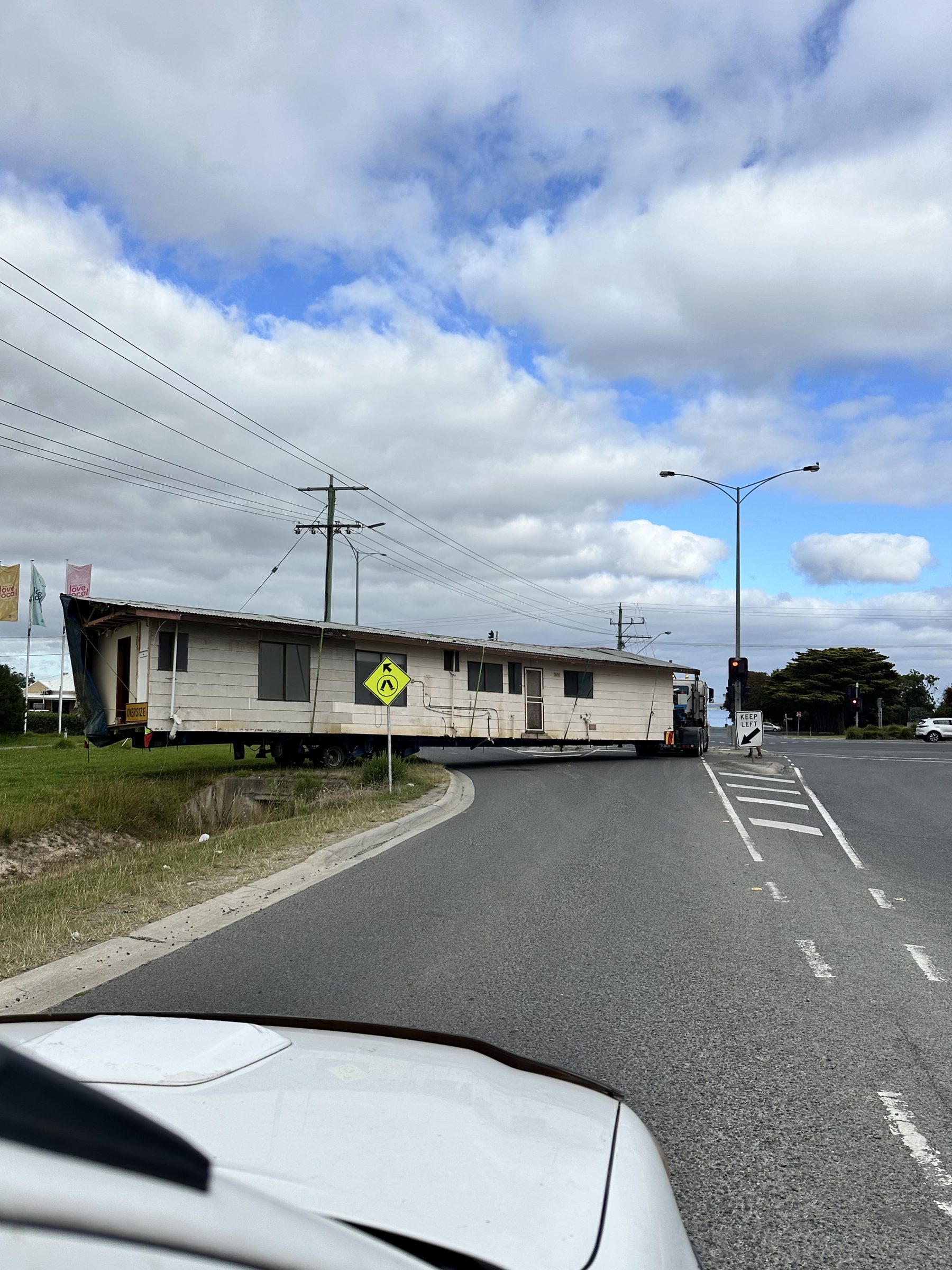 Long single-storey house being transported on truck
