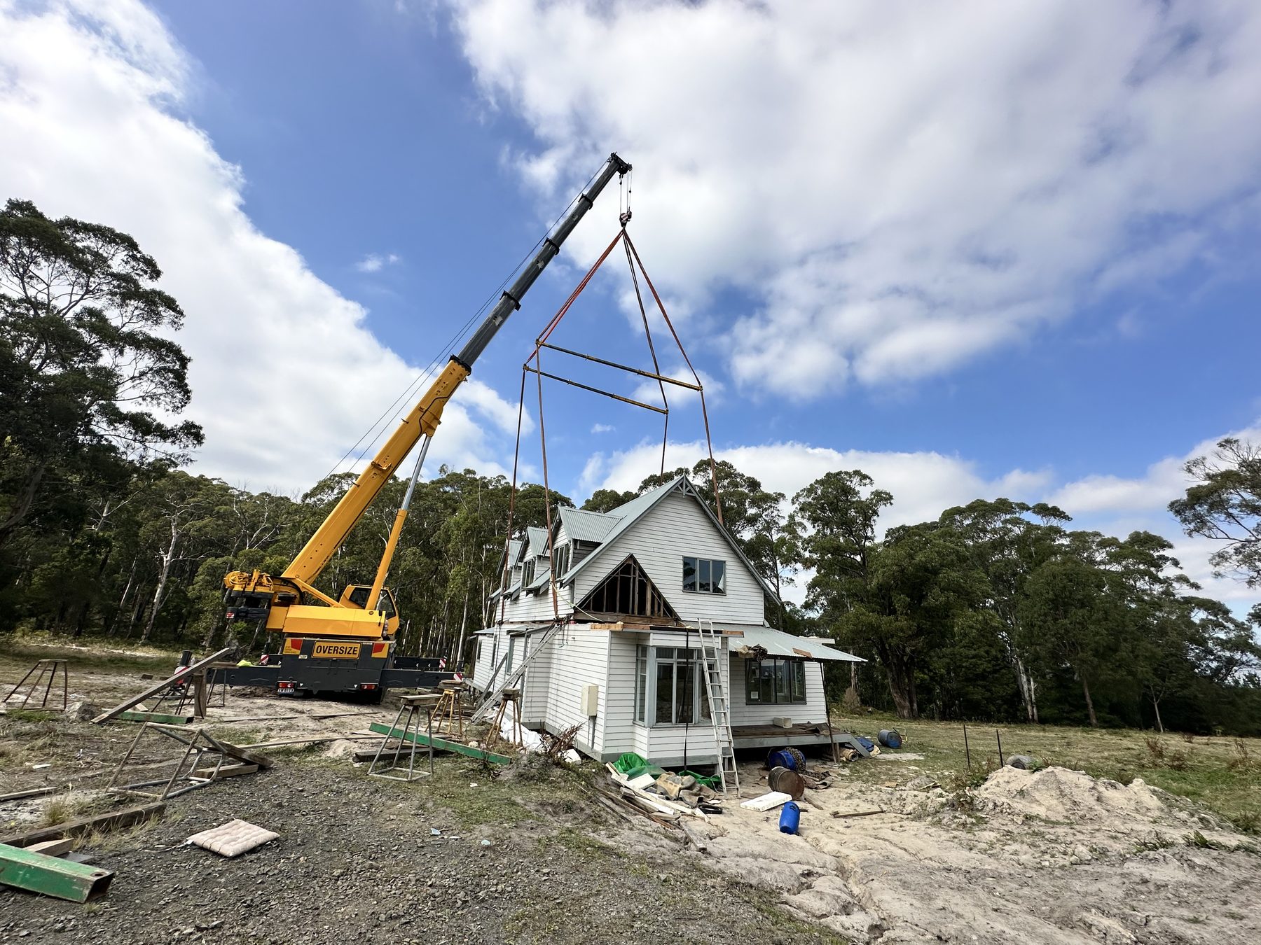 Crane lifting a two-storey house during relocation